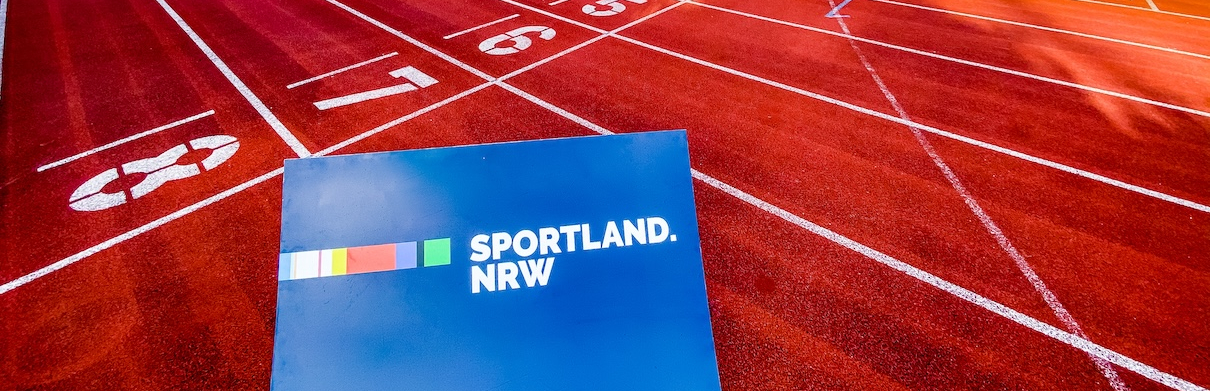 Laufbahn mit blauem Sportland.NRW-Schild